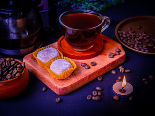 Cozy evening with a cup of coffee and tasty soft Japanese mochi cakes. Candle and flowers add comfort.