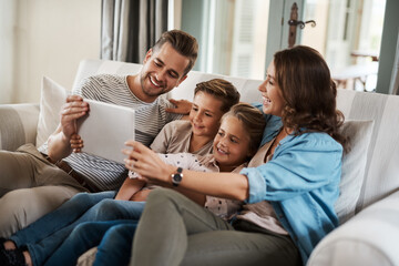 The best way to incorporate learning into playtime. Shot of a happy young family of four using a...