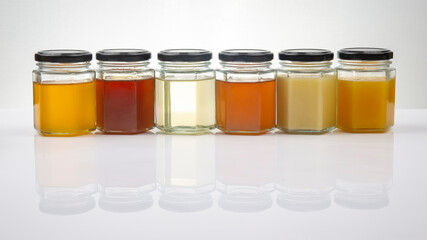 Hexagonal jars with different types and colors of fresh flower honey. vitamin food for health and life