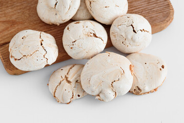 Photo of the meringue from above. Meringue on a brown board and next to it. meringue on the table. Chocolate meringue with stains.