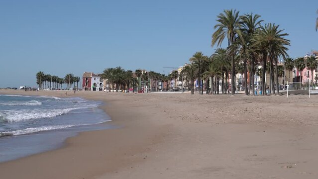 Spanish sandy beach Villajoyosa Spain with palm trees and waves Costa Blanca Alicante