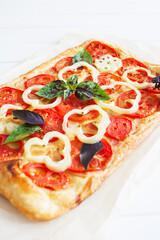 Ruddy rectangle pizza bacon white wooden background selective focus.