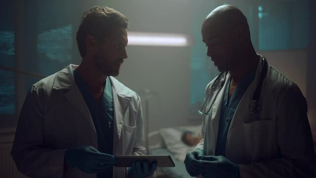 Portrait two doctors discussing patient records analyses on tablet hospital.