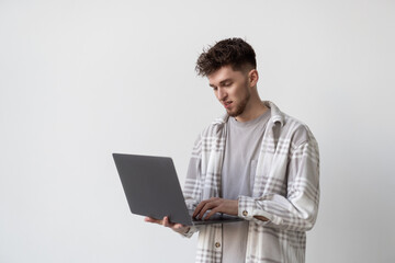 Portrait of a man using laptop computer over gray background