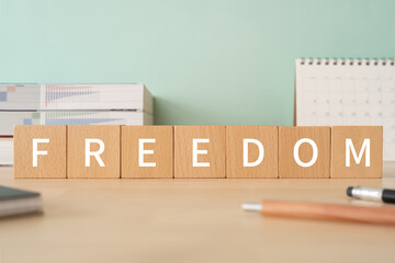 自由のイメージ｜「FREEDOM」と書かれた積み木が置かれたデスク