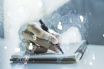 Double exposure of social network icons concept with world map and man hand writing in notebook on background. Marketing and promotion concept