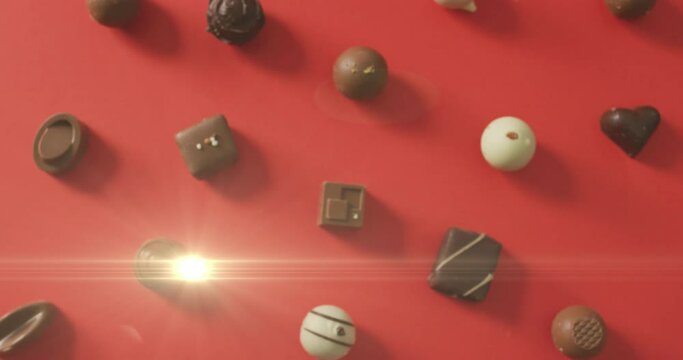 Animation of light over chocolate pralines on red surface