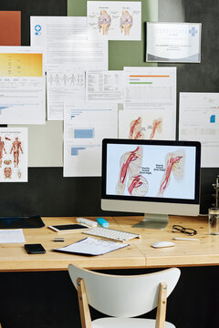 Image of computer with medical presentation on monitor for online education with medicine poster on wall in background