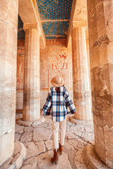 Happy woman traveler explores the ruins of the ancient egyptian Hatshepsut temple in the heritage...