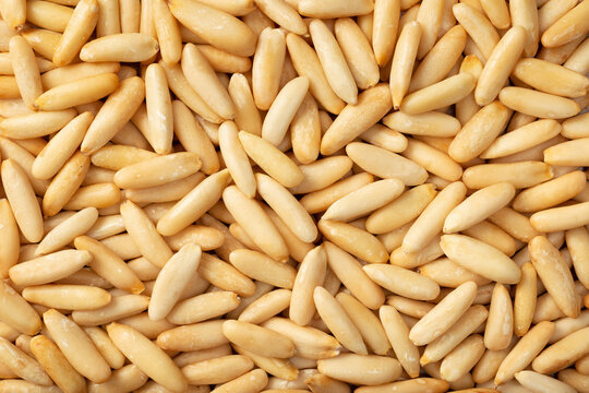 Food background of roasted European pine nuts, top view.