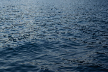 Naklejka premium Blue sea background, close-up. A backing with sea waves texture for branding, calendar, postcard, screensaver, wallpaper, poster, banner, cover, website. A place for your design or text