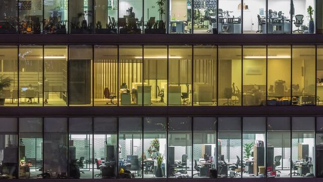 Big glowing windows in modern office buildings timelapse at night