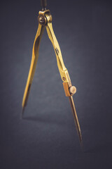 Old vintage pair of compasses on dark background