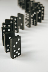 Black dominoes chain on white table background