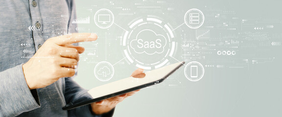 Obraz premium SaaS - software as a service concept with young man holding a tablet computer