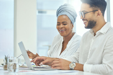 Two heads are always better than one. Cropped shot of two young diverse businesspeople working together on a laptop in their office.