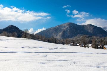 Fototapeta na wymiar Winter day in austrian alpine ski resort with cloudy sky and bright white snow. Steiermark, Upper Austria
