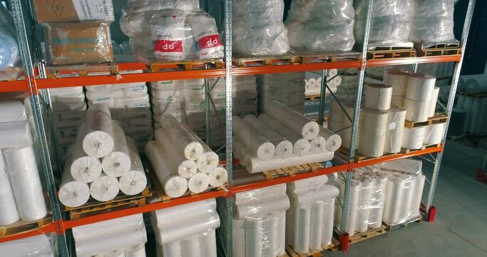 Spunbond on warehouse shelves. Rolls of padding polyester on the shelves of the warehouse. Spunbond in rolls. Non-Woven Fusible Interlining Fabric