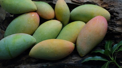 mango with mango leaves on wooden background