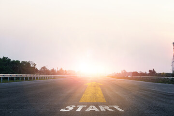 Start line wording with yellow arrow to glowing sunlight on super high way for business and...