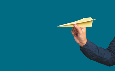Business startup concept. Hand holding a yellow rocket paper on a blue background.