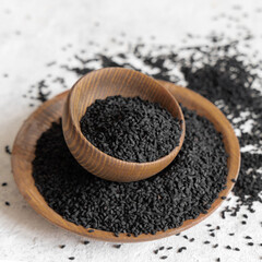 Indian spice Black cumin (nigella sativa or kalonji) seeds in wooden bowls close up