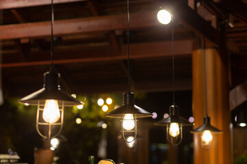 Several vintage yellow pendant lights provide light at night. - Powered by Adobe