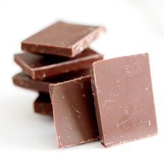 Chocolate pieces isolated on white background, close up. Milk chocolate.