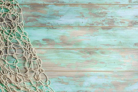 Fishing net on old cyan board background with copy space