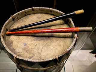 An old, worn drum with red and black drumsticks on it, the video is dynamic. High quality photo