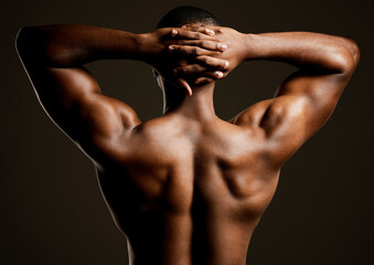Make muscles not excuses. Rearview studio shot of a fit young man posing against a black background.