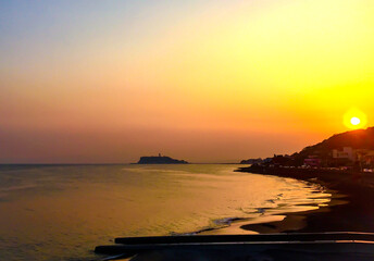 夕日で鮮やかなオレンジに染まる稲村ケ崎と江の島