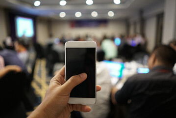 Mobile hold in hand with blur meeting room