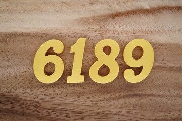 Golden Arabic numerals on a real brown and white wooden floor number 6189