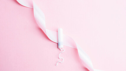 Menstrual tampon feminine hygiene. Pink ribbon with menstrual tampon on pink background. Menstruation feminine period. Sanitary hygiene concept. Medical healthcare gynecological banner.