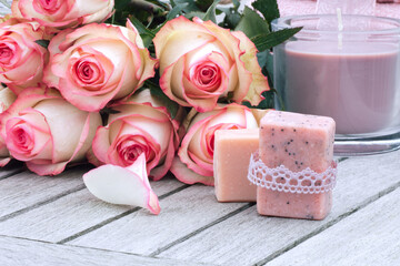Roses with scented candle and handmade soap on gray wood. Mother's day gift to relax.