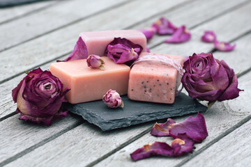 Dried purple roses and handmade fragrance soap on gray wooden planks. Mother's day gift to relax....