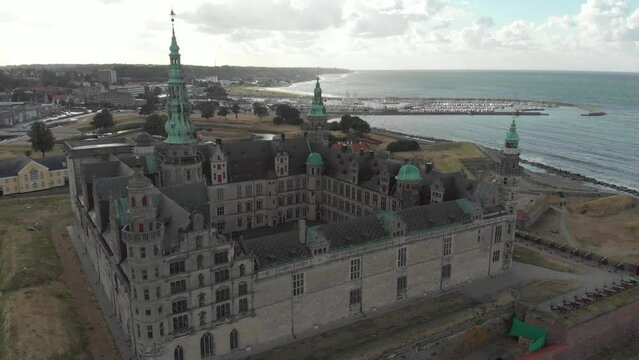 Cinematic 4K aerial drone dolly in shot of Kronborg Slot Castle, one of UNESCO's World Heritage sites, Helsing&oslash;r city and Marina in in Denmark