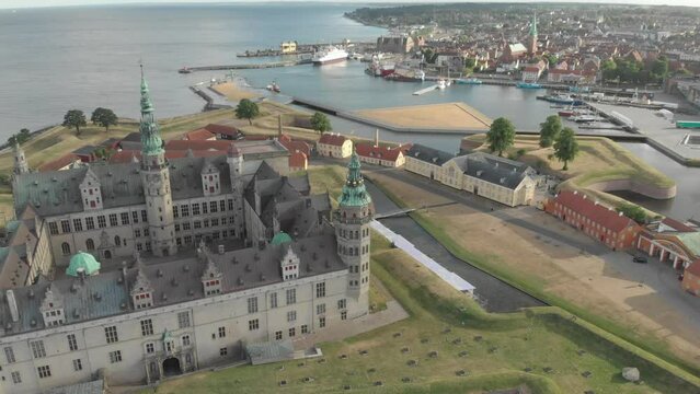 Cinematic 4K aerial drone pan shot of support buildings and museum by Kronborg Slot Castle, one of UNESCO's World Heritage sites, Helsing&oslash;r city and Marina in in Denmark