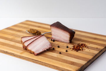 Smoked lard, bacon, half a piece, on a wooden craft background. Pork lard. Preserved pork.