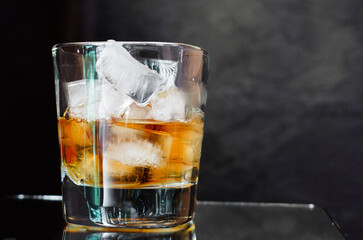 Glass of whiskey on the black background