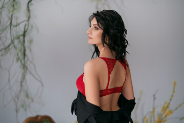 Dark-haired girl in a red bra with her back turned