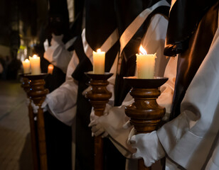 Semana santa Valladolid, varias velas encendidas portadas en báculos por hermanos de la cofradía de nuestro padre Jesús resucitado - obrazy, fototapety, plakaty