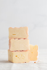 Sliced soft cheese with mold on a white background