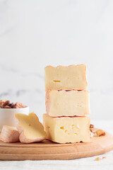 Sliced soft cheese with mold on a wooden board on a white background