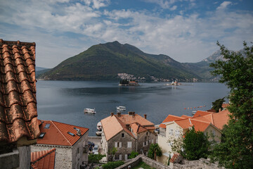 Naklejka na ściany i meble Scenic panorama view of the historic town of Perast at famous Bay of Kotor with mountains on a beautiful sunny day with blue sky and clouds in summer, Montenegro, southern Europe