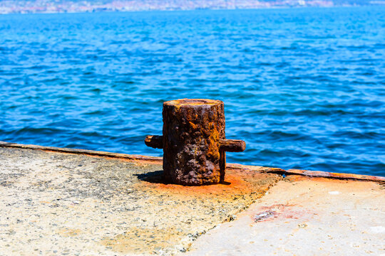 Old rusty mooring bollard at pier