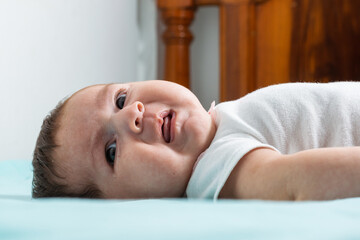 beautiful baby latina with an angry expression on her face as she looks to her right, lying on a...