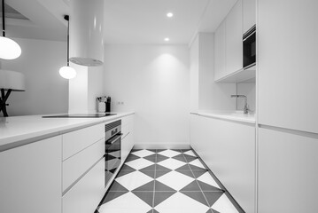 Kitchen with white wooden cabinets, straight lines and integrated appliances, gray and white floors and white hood