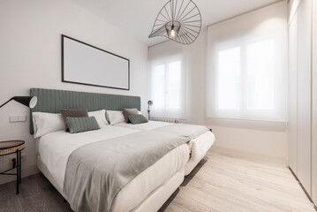 bedroom with double beds pushed together, green fabric headboard combined with green cushions and...